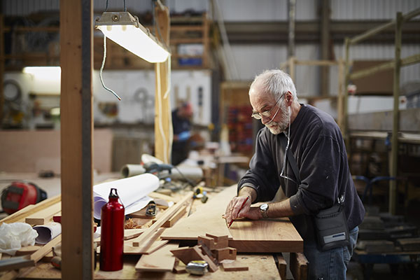 A man with COPD working in his woodshop with an Inogen Rove 6 portable oxygen concentrator